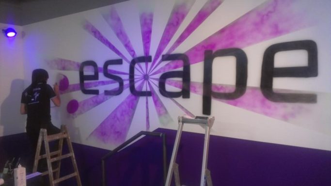 Logo einer Discothek im Eingangsbereich mit UV Farben, welche erst im Schwarzlicht leuchten