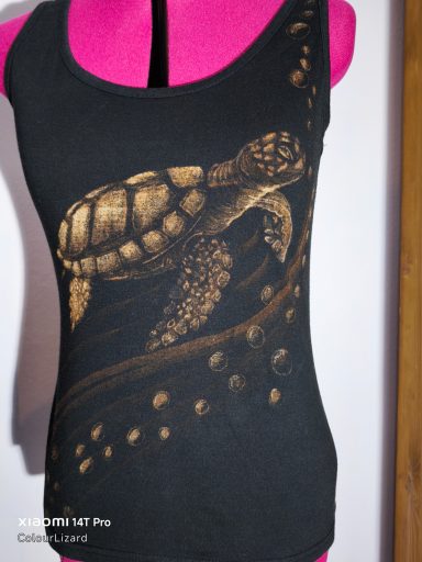 Ärmelloses Shirt mit einer Schildkröte getragen vom Wasserstrom mit Luftblasen