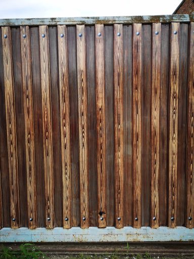 Detailaufnahme Metallzaun in Holzoptik bemalt