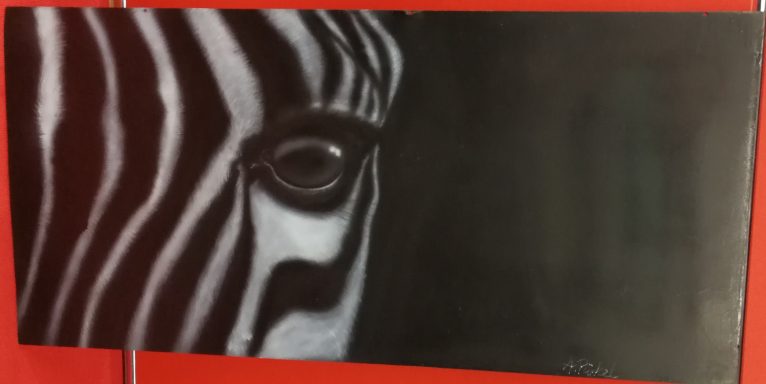 Messeauftritt Livebemalung:
Teilansicht eines Zebrakopfes auf einem Holzgrund