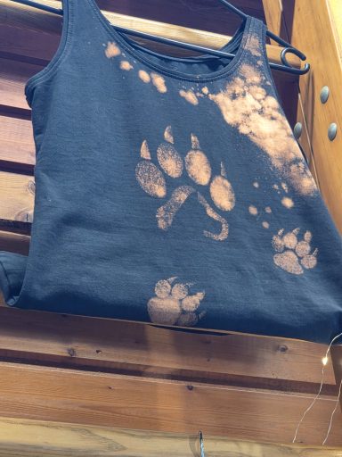 Tanktop mit mehreren  Pfotenaufdrucken. Im Ballen der großen Pfote sieht man die Silhouette eines Hundes