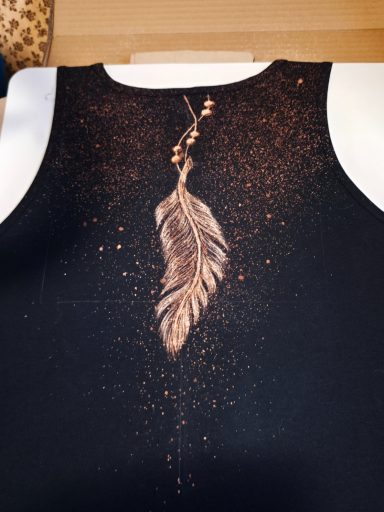 Feder mit Perlen im Nacken eines Tanktops. Gesprenkelter Hintergrund