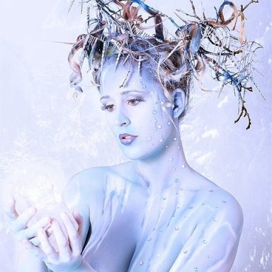 Studiopainting Eiswelt in blau und weiß. Mit einem Eiskristall in der Hand und Winterzweigen mit Eiszapfen in der Hochsteckfrisur.